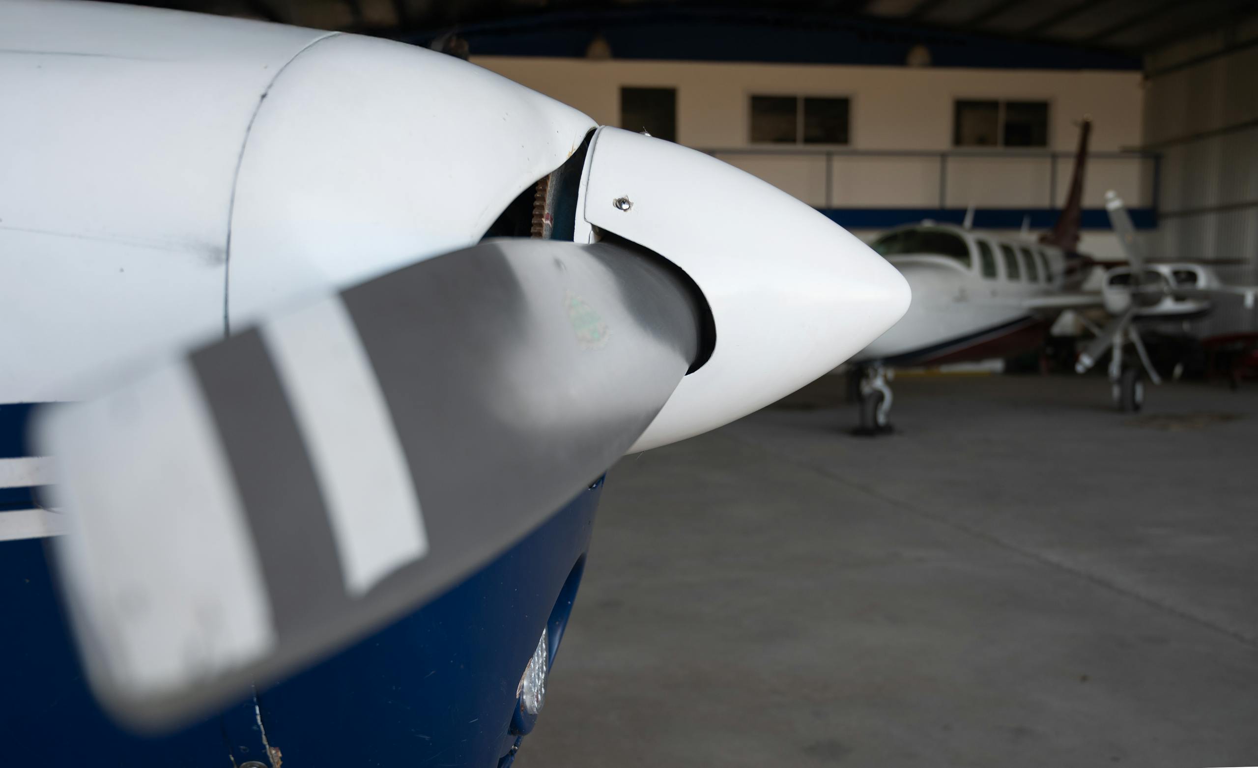 Detailed view of a small aircraft propeller inside a hangar, showcasing aviation engineering.